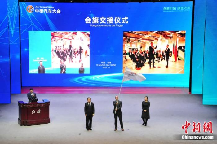 2021年10月19日，2021中德汽車大會在吉林長春舉行。中外汽車領(lǐng)域的專家學(xué)者、知名汽車廠商及汽車零部件企業(yè)代表和政府官員，圍繞“創(chuàng)新引領(lǐng) 綠色未來”主題展開探討。圖為中德汽車大會會旗交接儀式。高龍安 攝