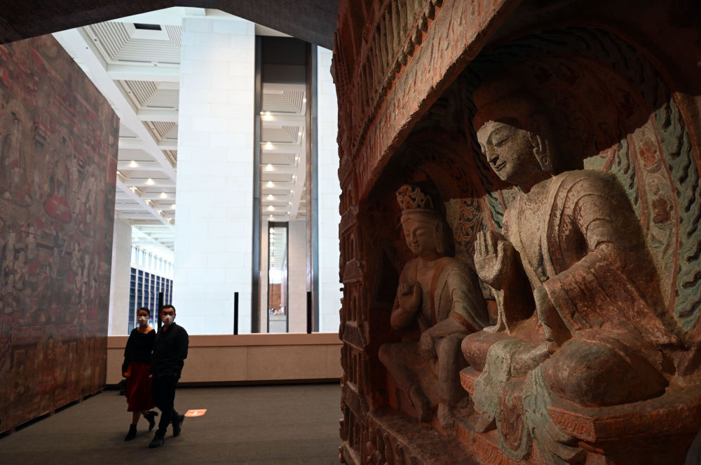 參觀者在中國(guó)國(guó)家博物館的“盛世修典——‘中國(guó)歷代繪畫(huà)大系’成果展”上觀看等比例高保真數(shù)字化3D打印復(fù)制的云岡石窟第6窟南壁“文殊問(wèn)疾”屋形龕(2022年9月29日攝)。新華社記者 金良快 攝