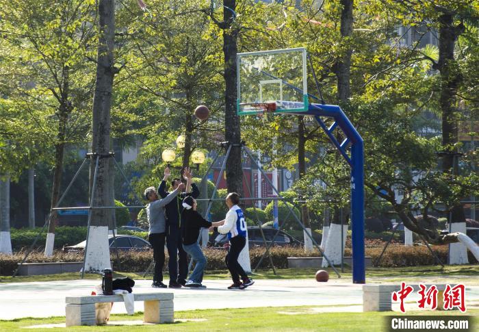 圖為市民、游客在防城港市公園廣場打籃球。　翟李強 攝