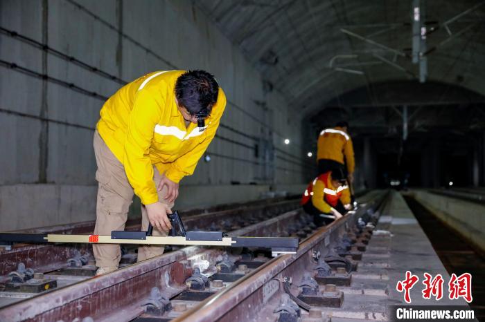 中國鐵路南寧局集團有限公司南寧工務(wù)段職工使用道尺檢查吳圩機場高鐵站高鐵線路設(shè)備?！№f剛 攝