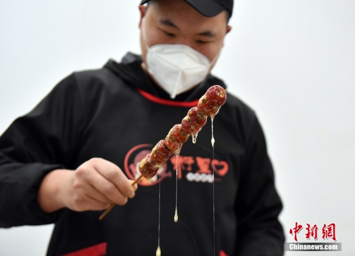 雄安新區(qū)大樹(shù)劉莊村辛愛(ài)青家中的冰糖葫蘆加工廠，工人正在制作冰糖葫蘆。作為遠(yuǎn)近聞名的“冰糖葫蘆村”，大樹(shù)劉莊村制作冰糖葫蘆的歷史已有100多年，全村三分之二的村民都會(huì)這門手藝，吸引不少游客慕名而來(lái)。 中新社記者 韓冰 攝